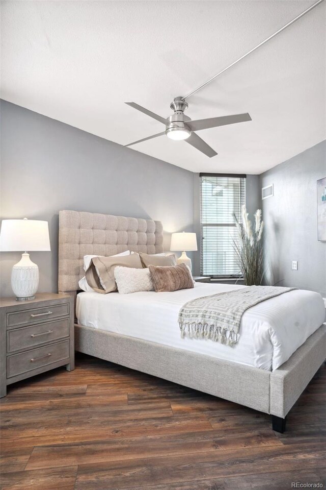 bedroom with dark hardwood / wood-style flooring and ceiling fan