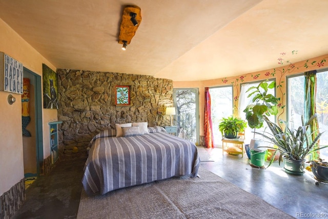 bedroom featuring multiple windows and concrete floors