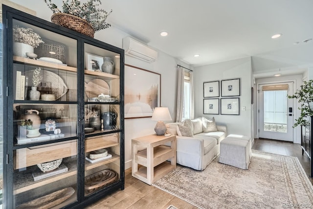 sitting room with recessed lighting, an AC wall unit, and wood finished floors