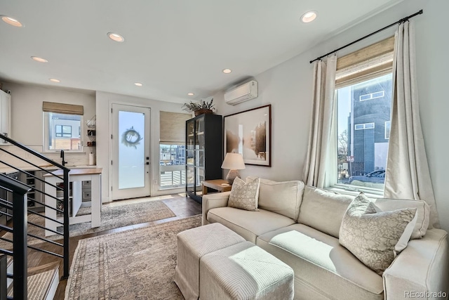 living room featuring stairs, a wall unit AC, and recessed lighting