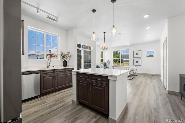 kitchen featuring sink, decorative light fixtures, dark brown cabinets, dishwasher, and a kitchen island