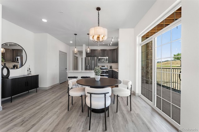 dining space with a chandelier and light hardwood / wood-style floors