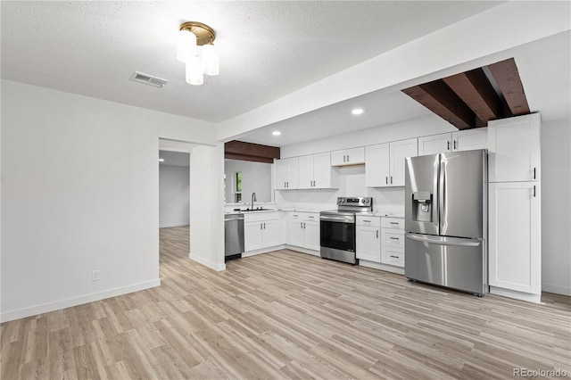 1347 S Crystal Way, Aurora, CO 80012 - kitchen with stainless steel appliances, light countertops, light wood-type flooring, white cabinetry, and a sink