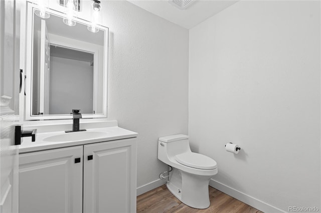 1347 S Crystal Way, Aurora, CO 80012 - bathroom with toilet, vanity, baseboards, and wood finished floors