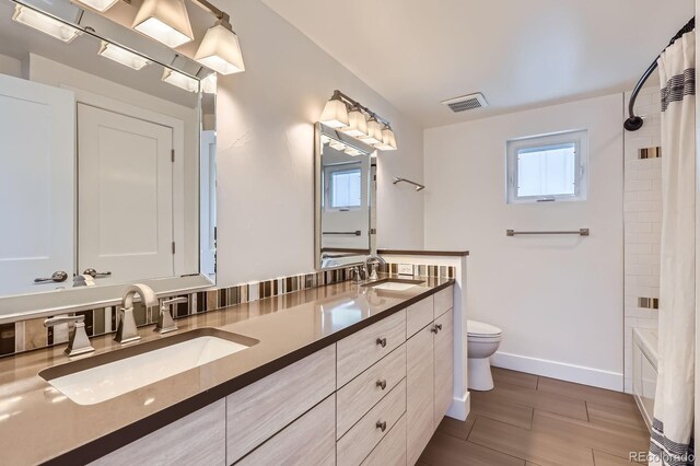 3640 Lipan St, Denver, CO 80211 - bathroom with double vanity, toilet, shower / bath combo with shower curtain, and baseboards