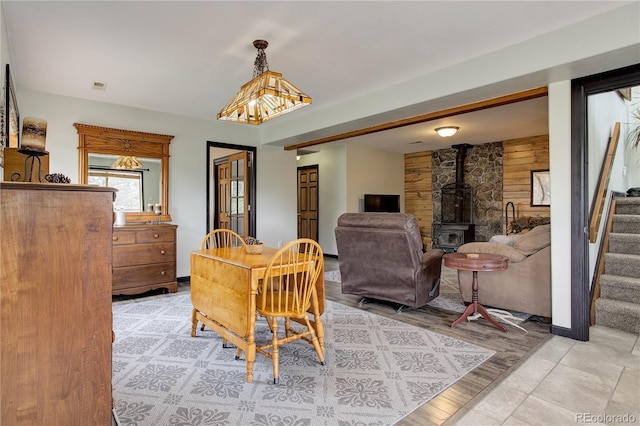 234 Bailey Dr, Bailey, CO 80421 - dining area with stairway, a wood stove, and wood walls
