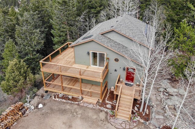 234 Bailey Dr, Bailey, CO 80421 - rustic home featuring a shingled roof, a wooden deck, and a wooded view