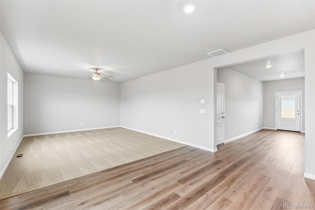 spare room featuring ceiling fan, light hardwood / wood-style flooring, and a healthy amount of sunlight