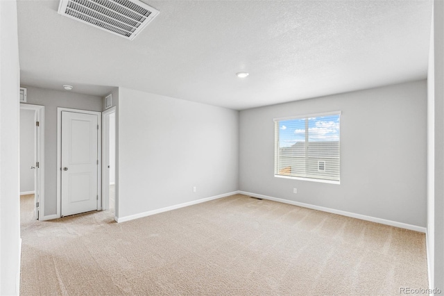 unfurnished room featuring light carpet