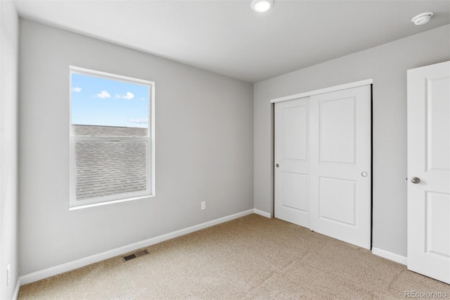 unfurnished bedroom with carpet and a closet