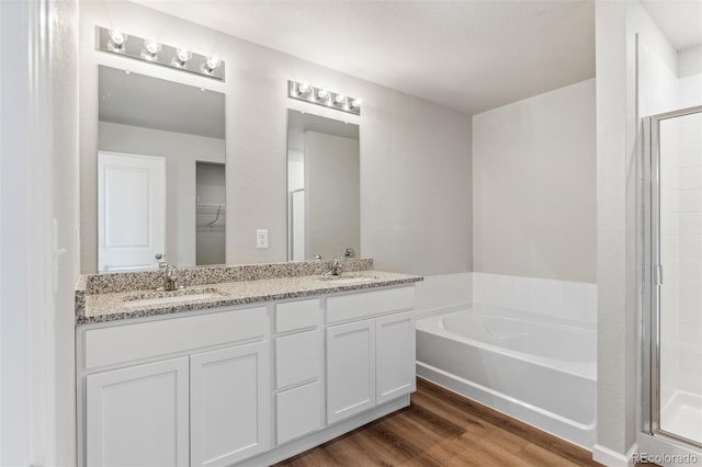 bathroom with wood-type flooring, vanity, a textured ceiling, and shower with separate bathtub