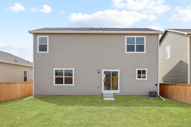 back of property with cooling unit and a lawn