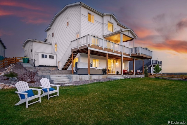 1601 Mariah Ln, Erie, CO 80516 - back of house at dusk featuring stairs, a wooden deck, a yard, and a hot tub