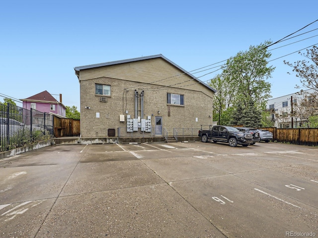 2460 W Caithness Pl Unit 105, Denver, CO 80211 - back of house featuring uncovered parking and fence