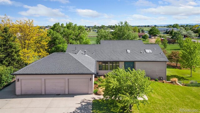 15132 Pecos St, Broomfield, CO 80023 - view of front of house featuring a front lawn, driveway, an attached garage, and roof with shingles