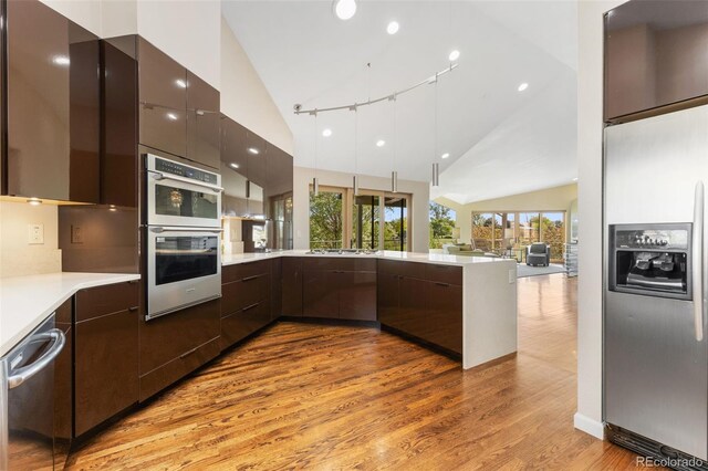 15132 Pecos St, Broomfield, CO 80023 - kitchen with appliances with stainless steel finishes, modern cabinets, lofted ceiling, light wood-style floors, and a peninsula