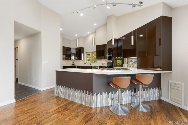 15132 Pecos St, Broomfield, CO 80023 - kitchen with dark wood-style floors, modern cabinets, light countertops, a peninsula, and recessed lighting