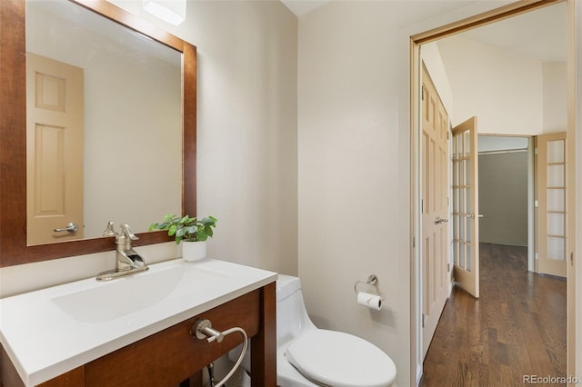 15132 Pecos St, Broomfield, CO 80023 - half bathroom featuring wood finished floors, vanity, toilet, and french doors