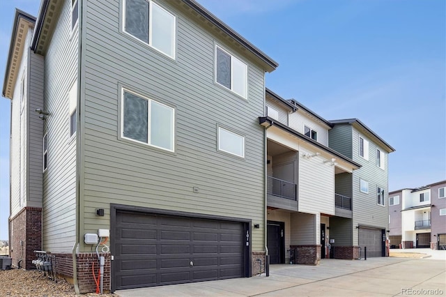 453 Interlocken Blvd Unit 101, Broomfield, CO 80021 - exterior space featuring cooling unit, brick siding, concrete driveway, and a garage