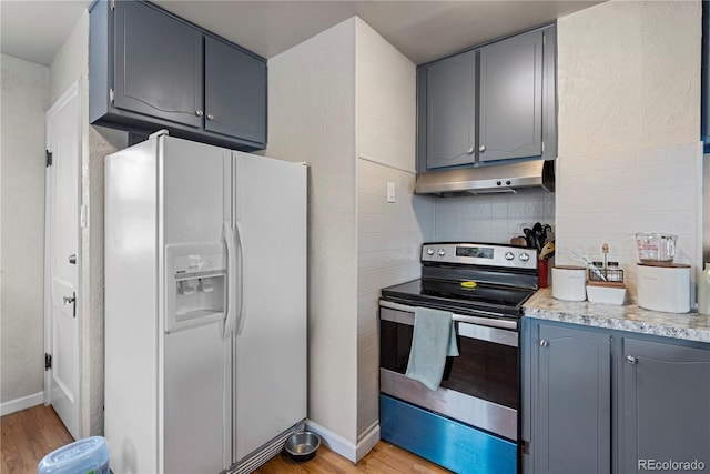 2041 7th Ave, Greeley, CO 80631 - kitchen with white fridge with ice dispenser, stainless steel range with electric cooktop, under cabinet range hood, light wood finished floors, and gray cabinetry