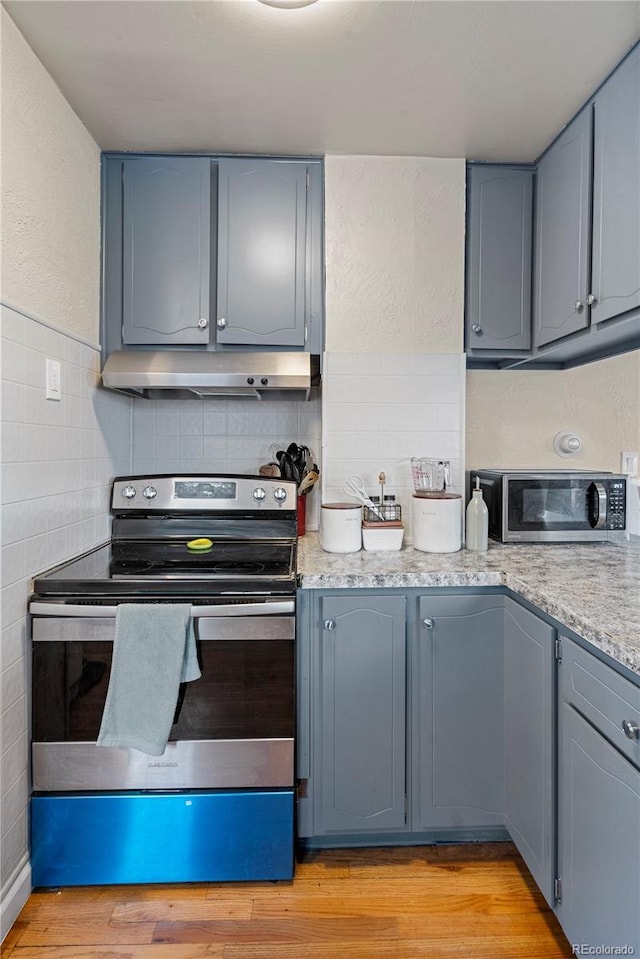 2041 7th Ave, Greeley, CO 80631 - kitchen featuring appliances with stainless steel finishes, extractor fan, gray cabinets, light stone counters, and tile walls