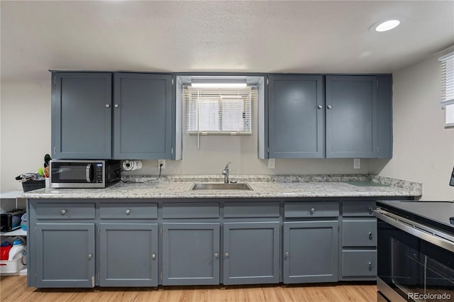 2041 7th Ave, Greeley, CO 80631 - kitchen with appliances with stainless steel finishes, light wood-style floors, light countertops, and gray cabinets