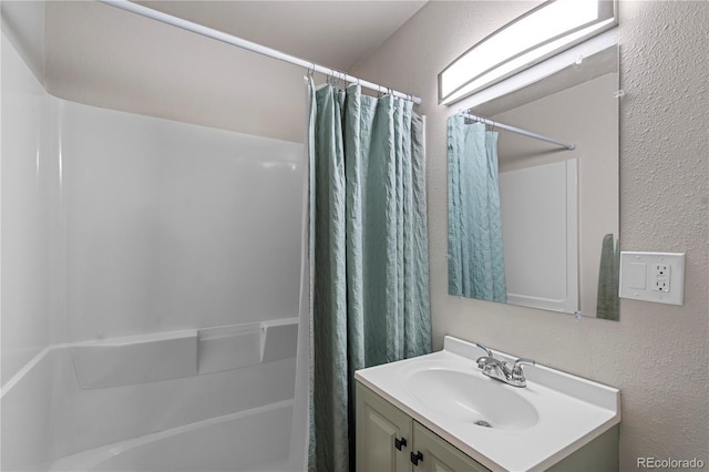 2041 7th Ave, Greeley, CO 80631 - bathroom with vanity, shower / bath combo with shower curtain, and a textured wall