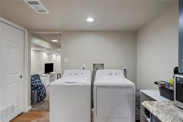 2041 7th Ave, Greeley, CO 80631 - laundry room with washer and clothes dryer, light wood finished floors, and recessed lighting