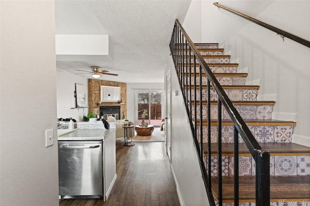 4160 Baytown Dr, Colorado Springs, CO 80916 - stairway featuring baseboards, a textured ceiling, a large fireplace, ceiling fan, and wood finished floors