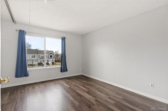 4160 Baytown Dr, Colorado Springs, CO 80916 - empty room with dark wood-type flooring, baseboards, and a textured ceiling