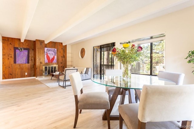2525 S Dayton Way Unit 1201, Denver, CO 80231 - dining room with beamed ceiling, wooden walls, wood finished floors, and a glass covered fireplace