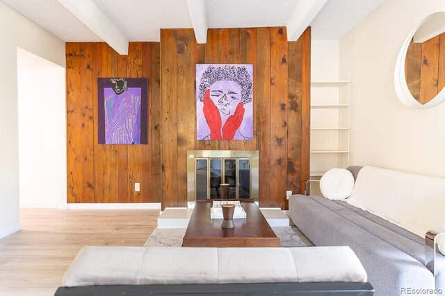 2525 S Dayton Way Unit 1201, Denver, CO 80231 - living area with wooden walls, beam ceiling, wood finished floors, and a glass covered fireplace