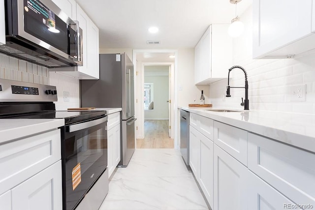 2525 S Dayton Way Unit 1201, Denver, CO 80231 - kitchen with appliances with stainless steel finishes, white cabinets, light countertops, tasteful backsplash, and recessed lighting