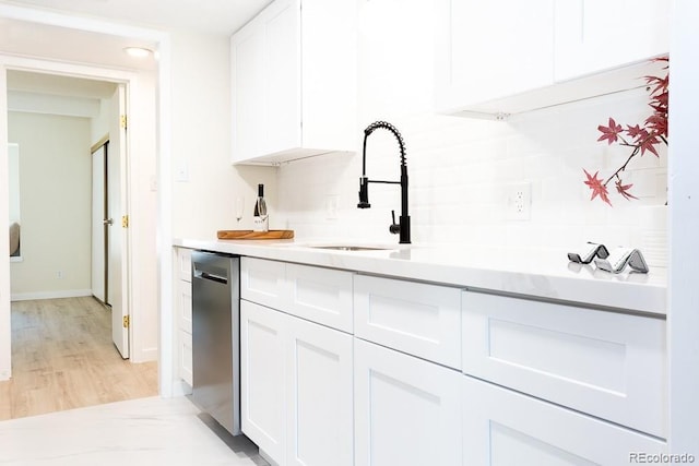 2525 S Dayton Way Unit 1201, Denver, CO 80231 - kitchen with dishwasher, white cabinetry, light countertops, backsplash, and light wood-style floors