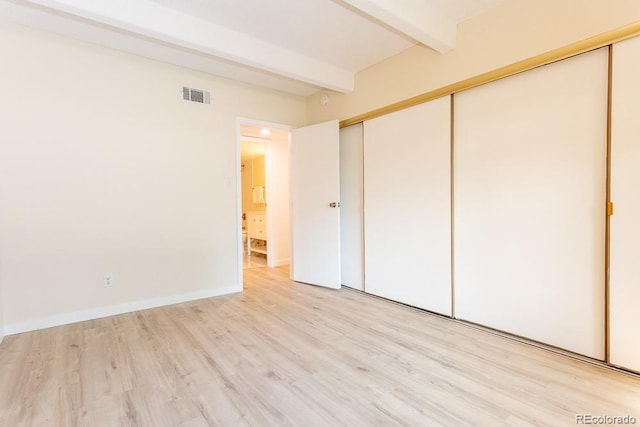 2525 S Dayton Way Unit 1201, Denver, CO 80231 - unfurnished bedroom featuring beamed ceiling, light wood-style flooring, and a closet
