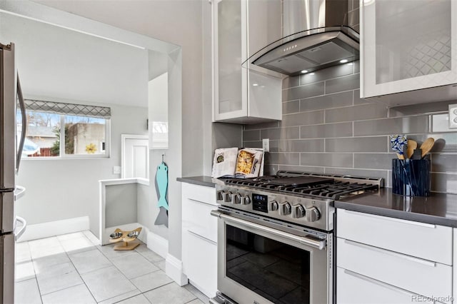 kitchen with white cabinetry, stainless steel appliances, island exhaust hood, tasteful backsplash, and light tile patterned flooring