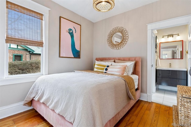 bedroom featuring hardwood / wood-style flooring and ensuite bath