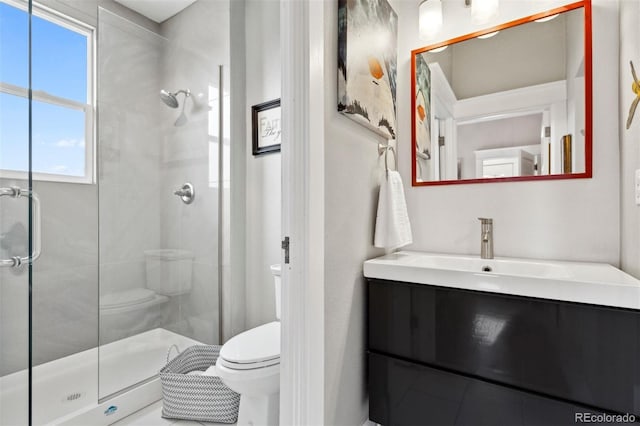 bathroom with an enclosed shower, vanity, and toilet