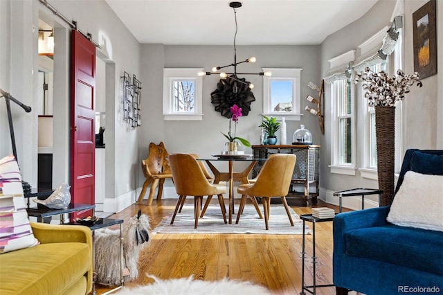 dining area featuring wood-type flooring and a chandelier