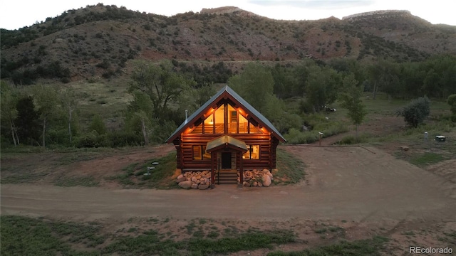 view of front of property with a mountain view, driveway, and log siding
