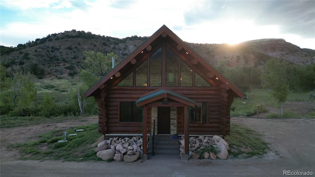 cabin with a mountain view and log siding