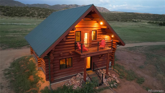 view of front of house with a balcony and a mountain view