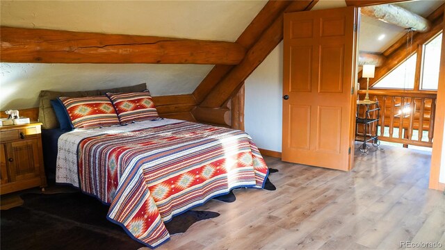 bedroom featuring lofted ceiling and light hardwood / wood-style floors