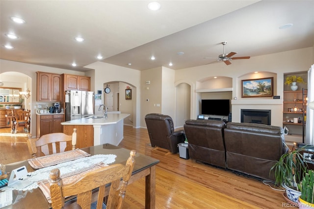 dining area featuring sink, built in features, ceiling fan, and light wood-type flooring