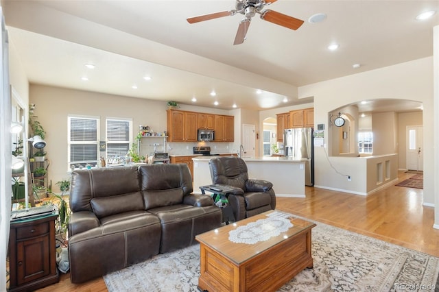 living room featuring ceiling fan and light hardwood / wood-style flooring