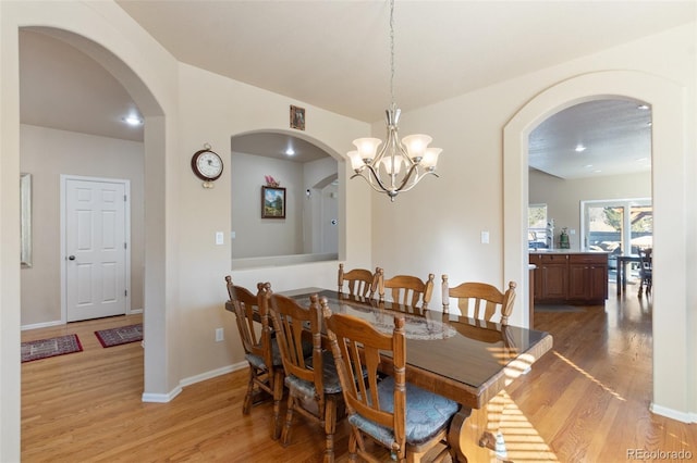 dining area featuring an inviting chandelier and light hardwood / wood-style floors