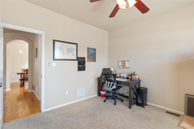 carpeted office space with ceiling fan