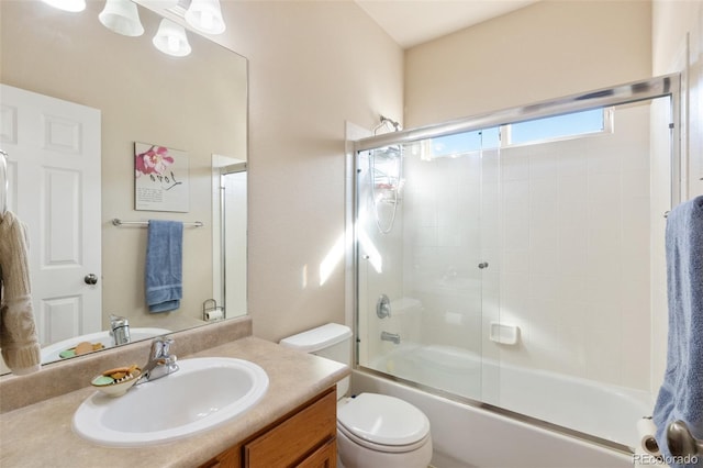 full bathroom with vanity, shower / bath combination with glass door, and toilet