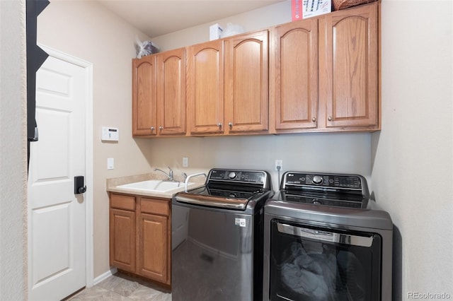 clothes washing area featuring cabinets, washer and clothes dryer, and sink