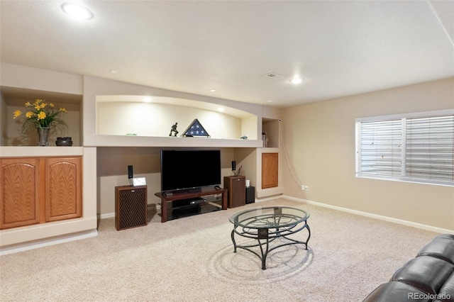 living room featuring carpet floors and built in shelves